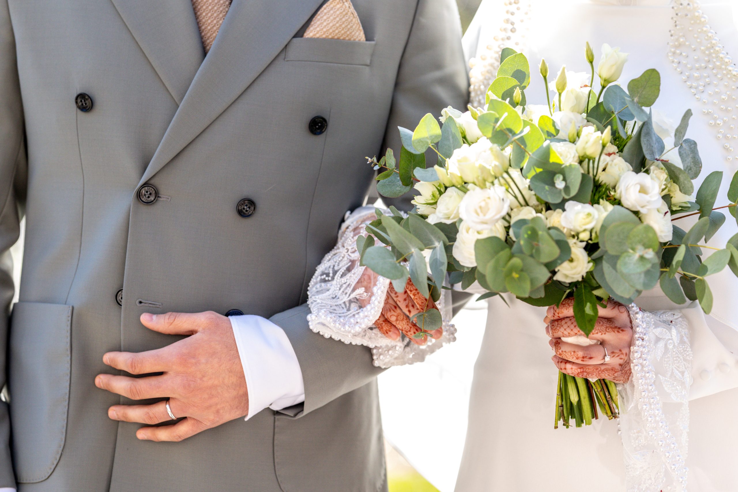 Détails des alliances et du bouquet de mariage en lumière naturelle
