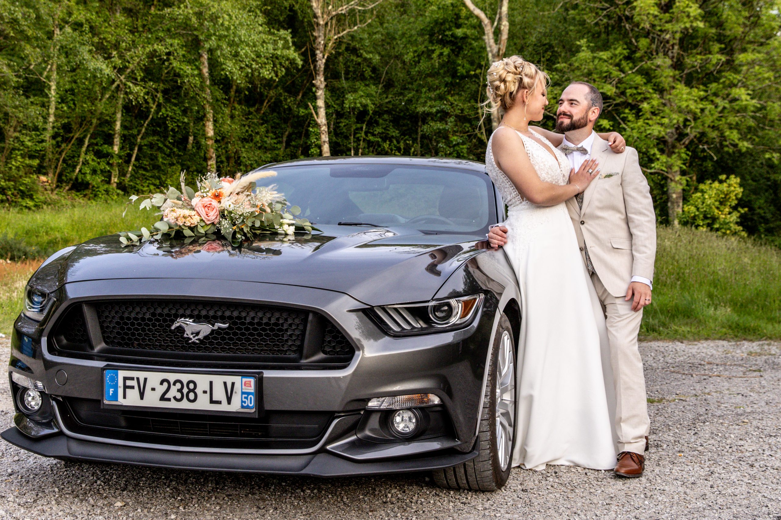 Couple de mariés lors d’un portrait de mariage en extérieur avec leur voiture en Normandie